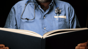 A healthcare professional reading medical communications articles in a scientific publication.