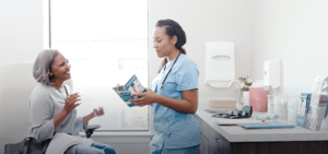 A physician gives her patient a pamphlet to keep her informed and up to date on her healthcare journey. 